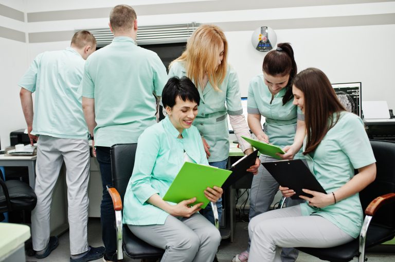 Medical theme.Observation room with a computer tomograph. The group of female doctors with clipboards meeting in the mri office at diagnostic center in hospital.